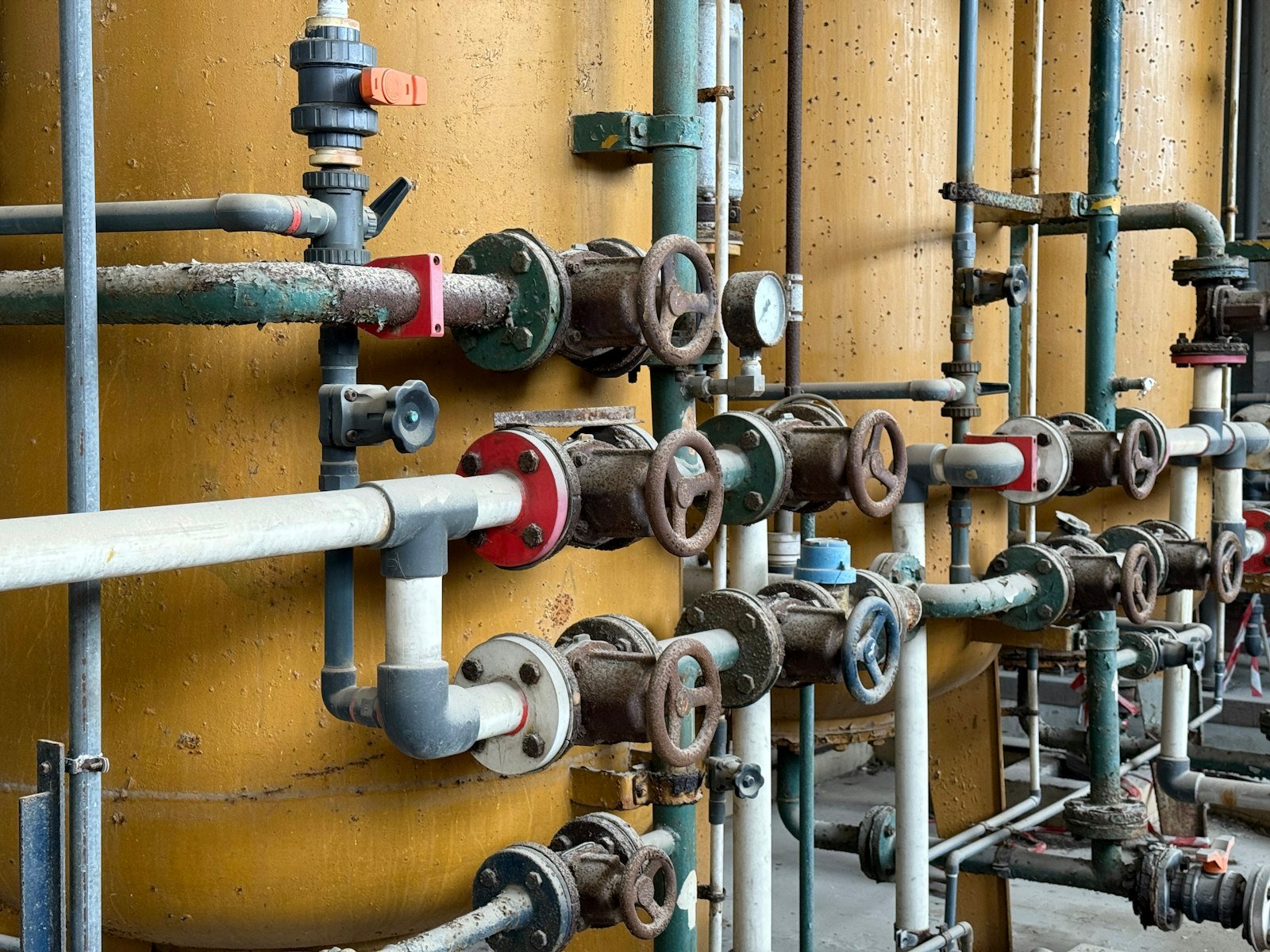 Żółte zbiorniki z rurami i kołami zaworów